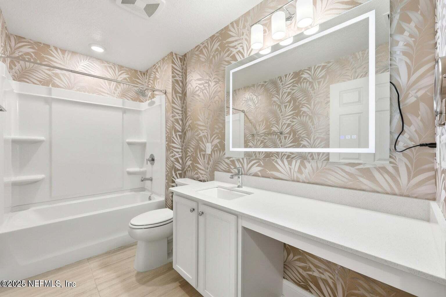 251 Rambling Brk Trail St. Johns, FL 32259 - Photo 33 of 40 a bathroom with a granite countertop sink a toilet a mirror a bathtub and shower