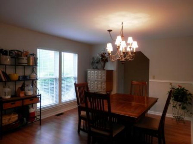 2091 Smith Road Forsyth, GA 31029 - Photo 10 of 13 a dining room with furniture a chandelier and wooden floor