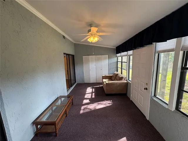 a living room with furniture and a hallway