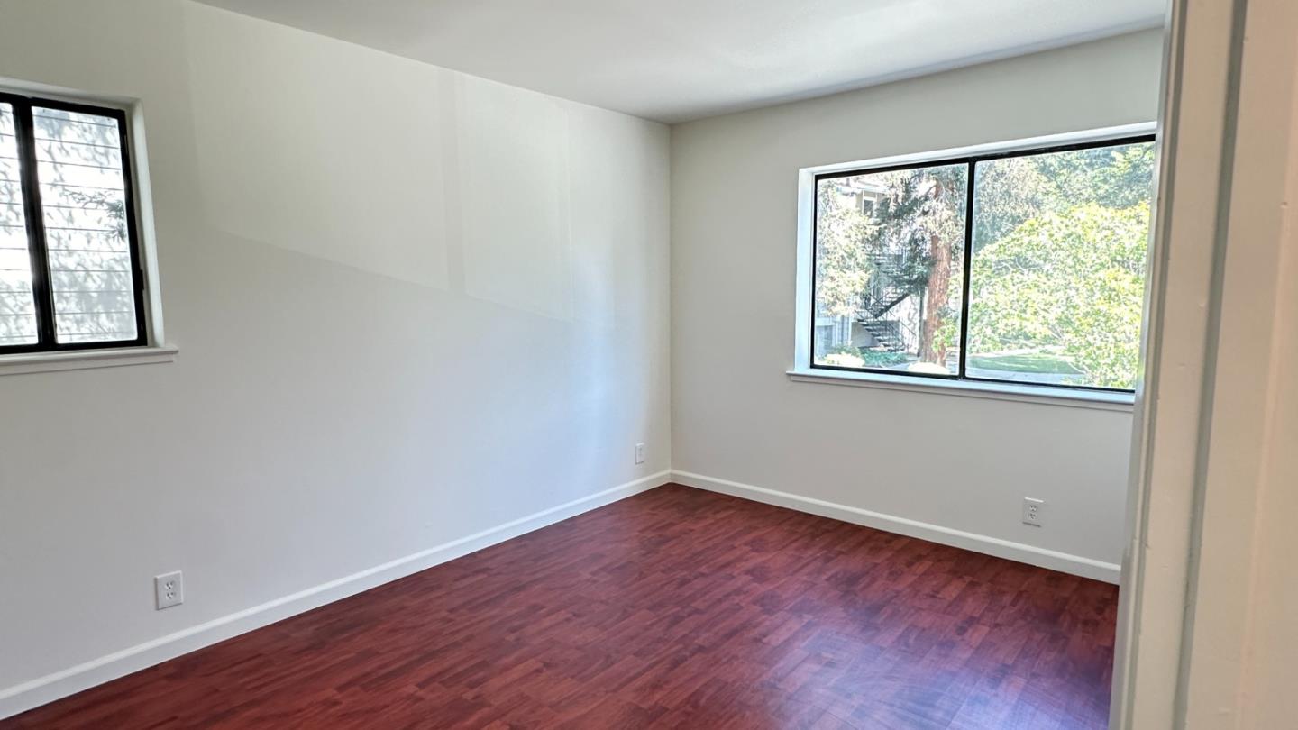 274 Stonegate Circle San Jose, CA 95110 - Photo 13 of 20 an empty room with wooden floor and windows