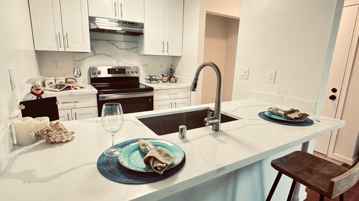 274 Stonegate Circle San Jose, CA 95110 - Photo 3 of 20 a kitchen with a sink a stove and white cabinets with wooden floor