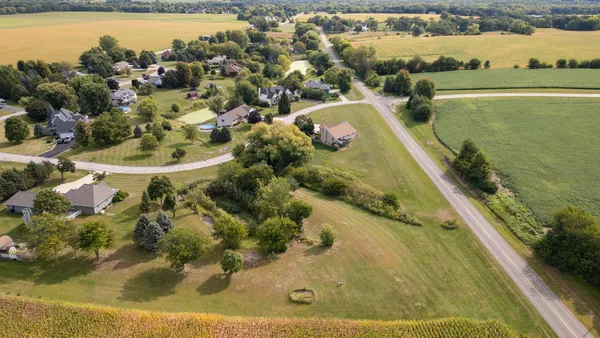 an aerial view of residential houses with outdoor space and swimming pool
