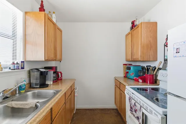 a kitchen with stainless steel appliances a sink dishwasher and cabinets with wooden floor