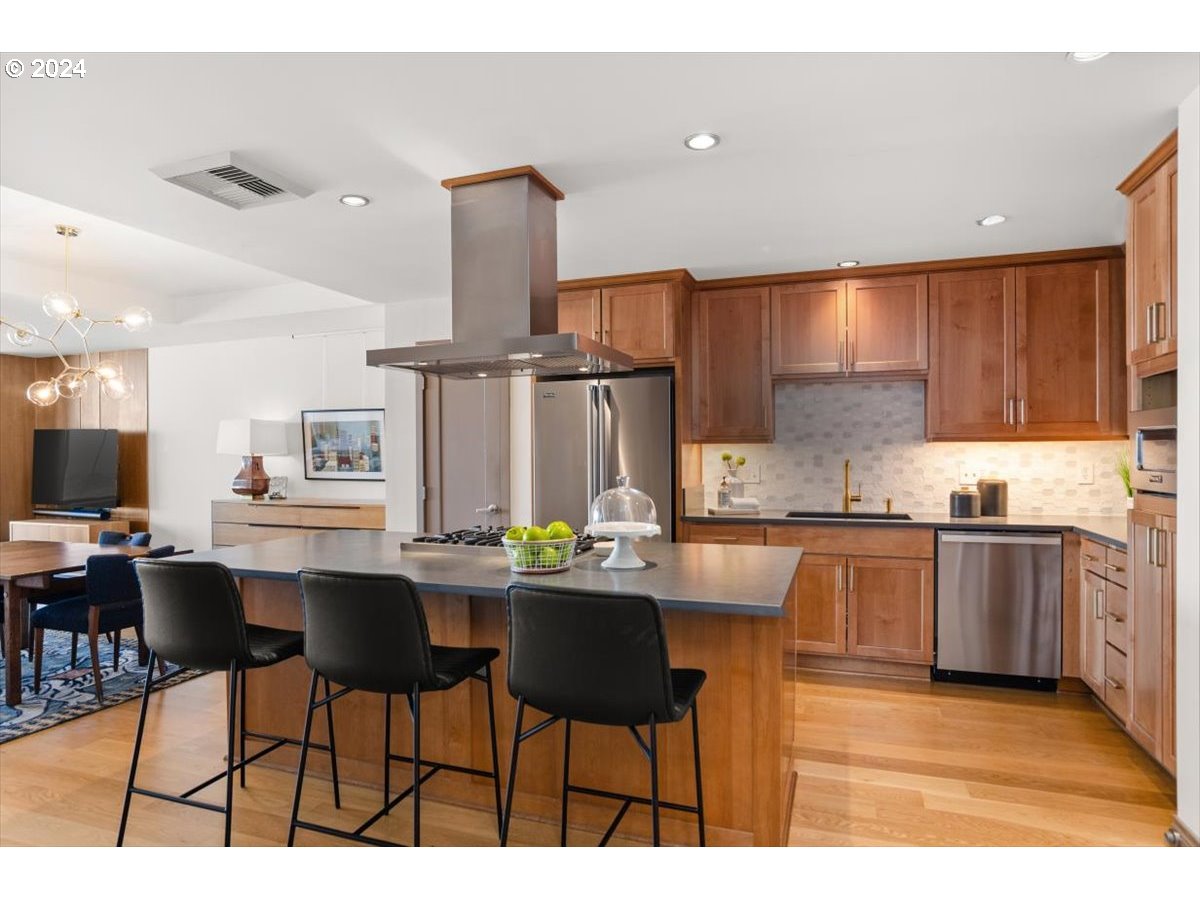 2454 Northwest Westover Road, Unit 5205 Portland, OR 97210 - Photo 12 of 33 a kitchen with stainless steel appliances kitchen island granite countertop a sink and cabinets