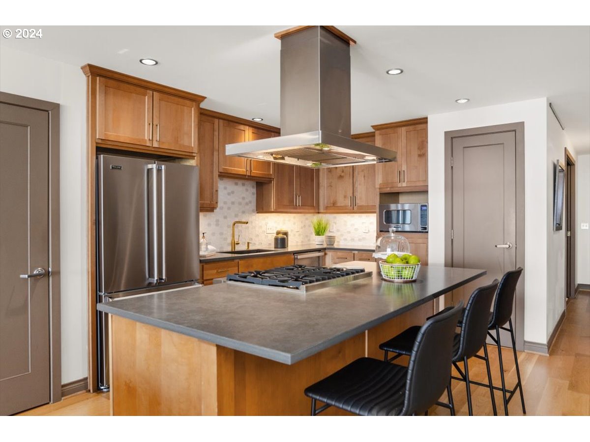 2454 Northwest Westover Road, Unit 5205 Portland, OR 97210 - Photo 13 of 33 a kitchen with a sink a stove and chairs