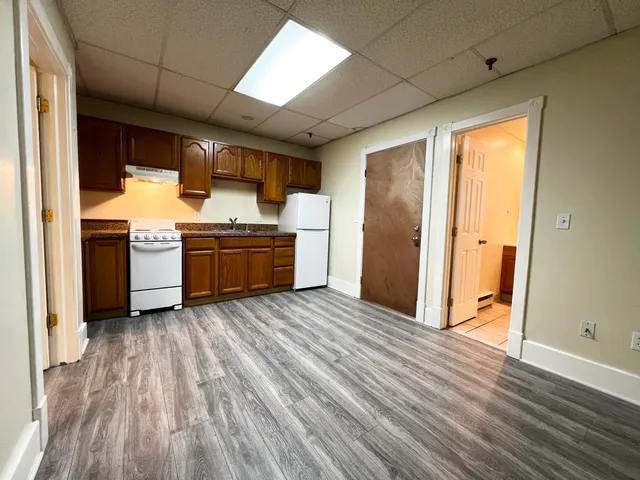 a kitchen with kitchen island wooden floors and stainless steel appliances