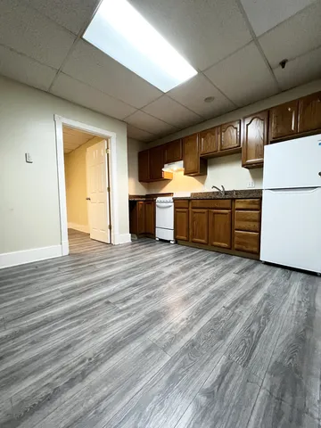 a kitchen with stainless steel appliances wooden floors and wooden cabinets