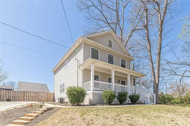a front view of a house with a yard and potted plants
