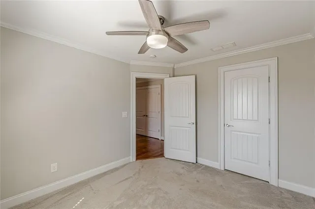 an empty room with closet and a ceiling fan