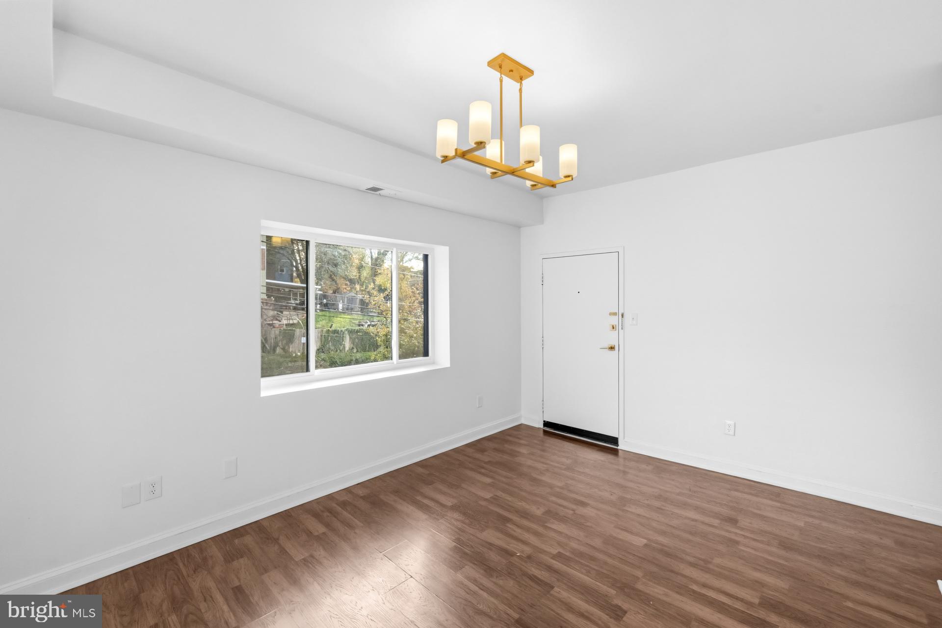 2834 R Street Southeast, Unit 6 Washington, DC 20020 - Photo 8 of 33 an empty room with wooden floor chandelier and a window