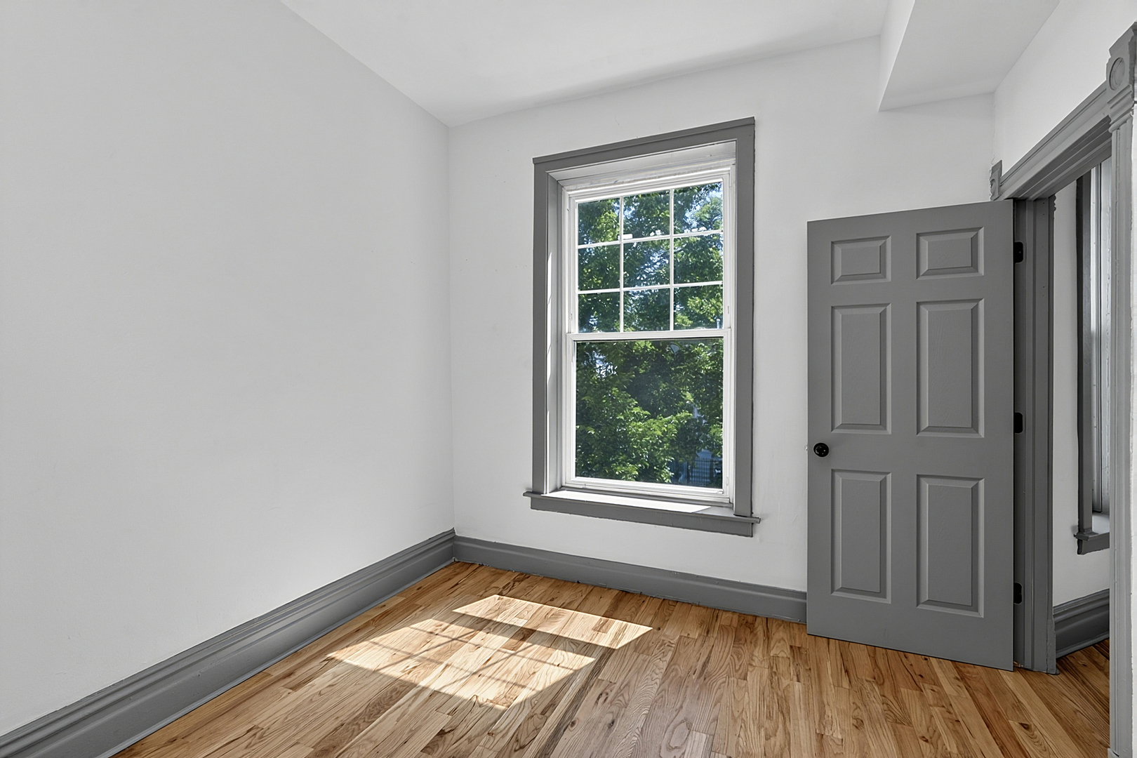 6602 South Marquette Road Chicago, IL 60637 - Photo 9 of 24 an empty room with wooden floor and windows