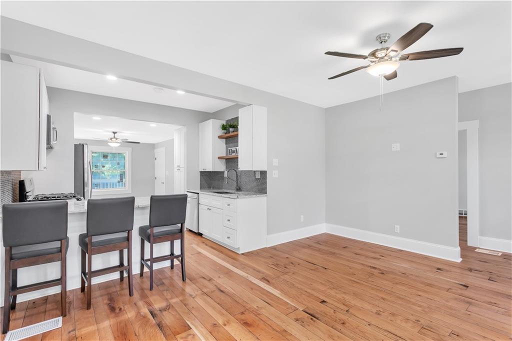 An adorable breakfast bar creates a distinct eating space in otherwise a very open layout.