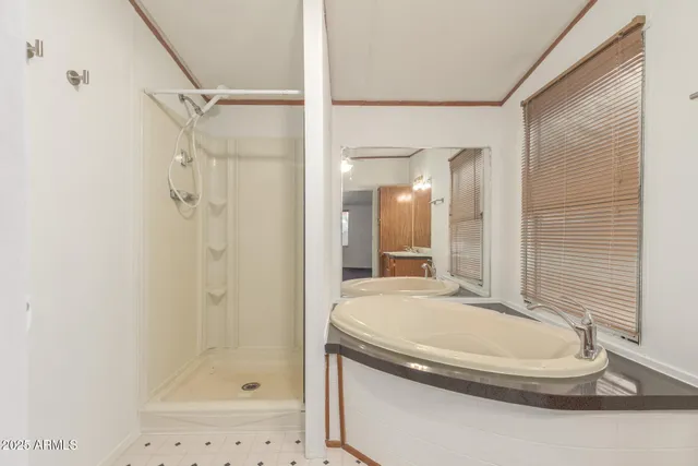 a bathroom with a granite countertop sink a mirror and a shower