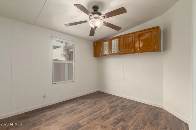 an empty room with windows and fan