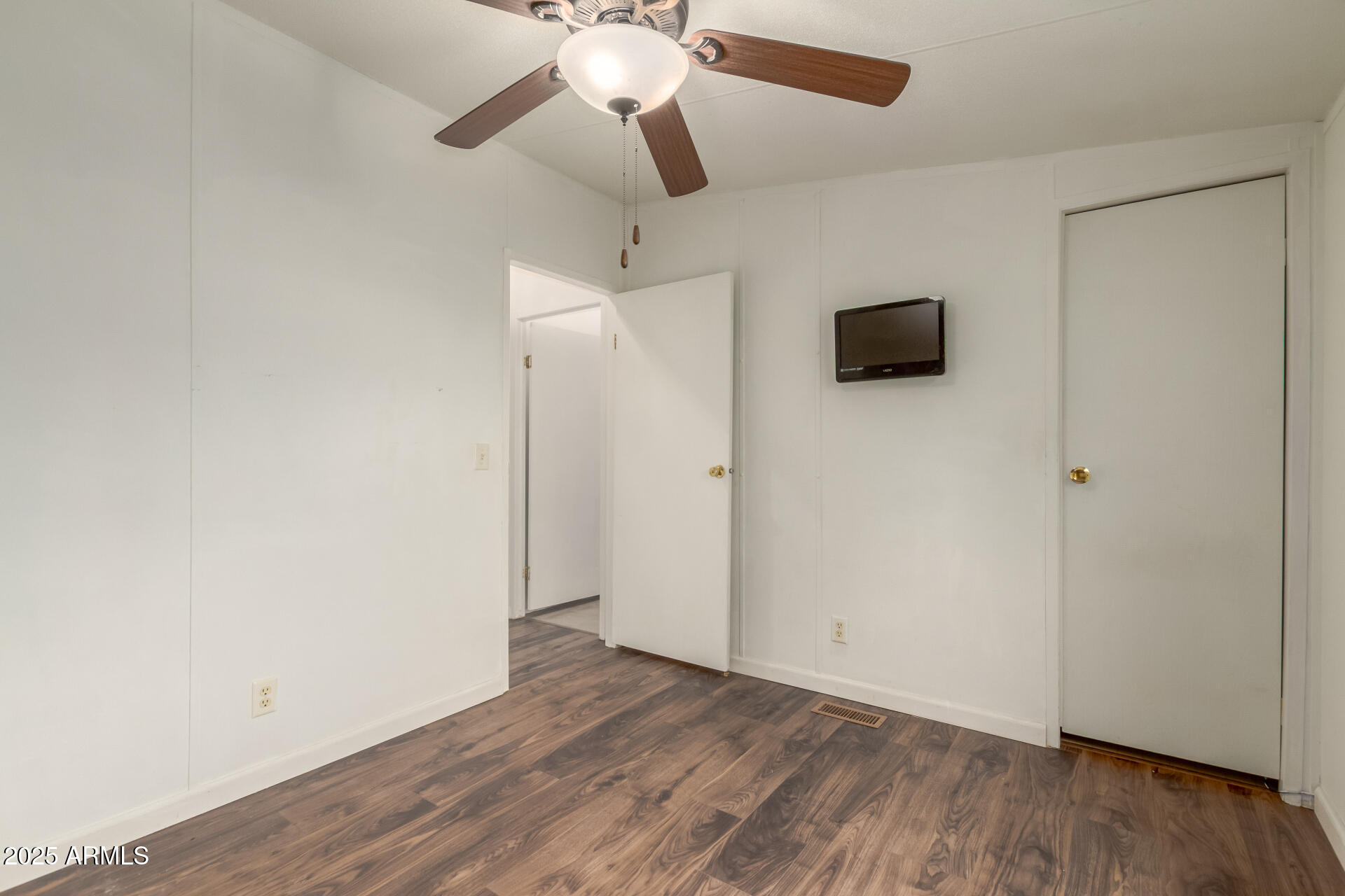 11404 West Custer Road Arizona City, AZ 85123 - Photo 17 of 27 an empty room with wooden floor a ceiling fan and closet