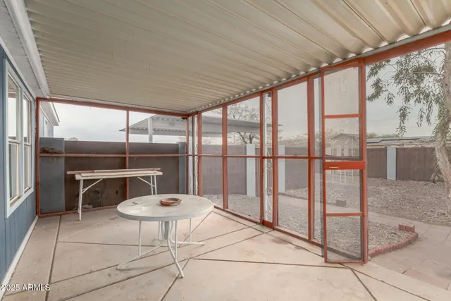 a living room with a floor to ceiling windows and a table