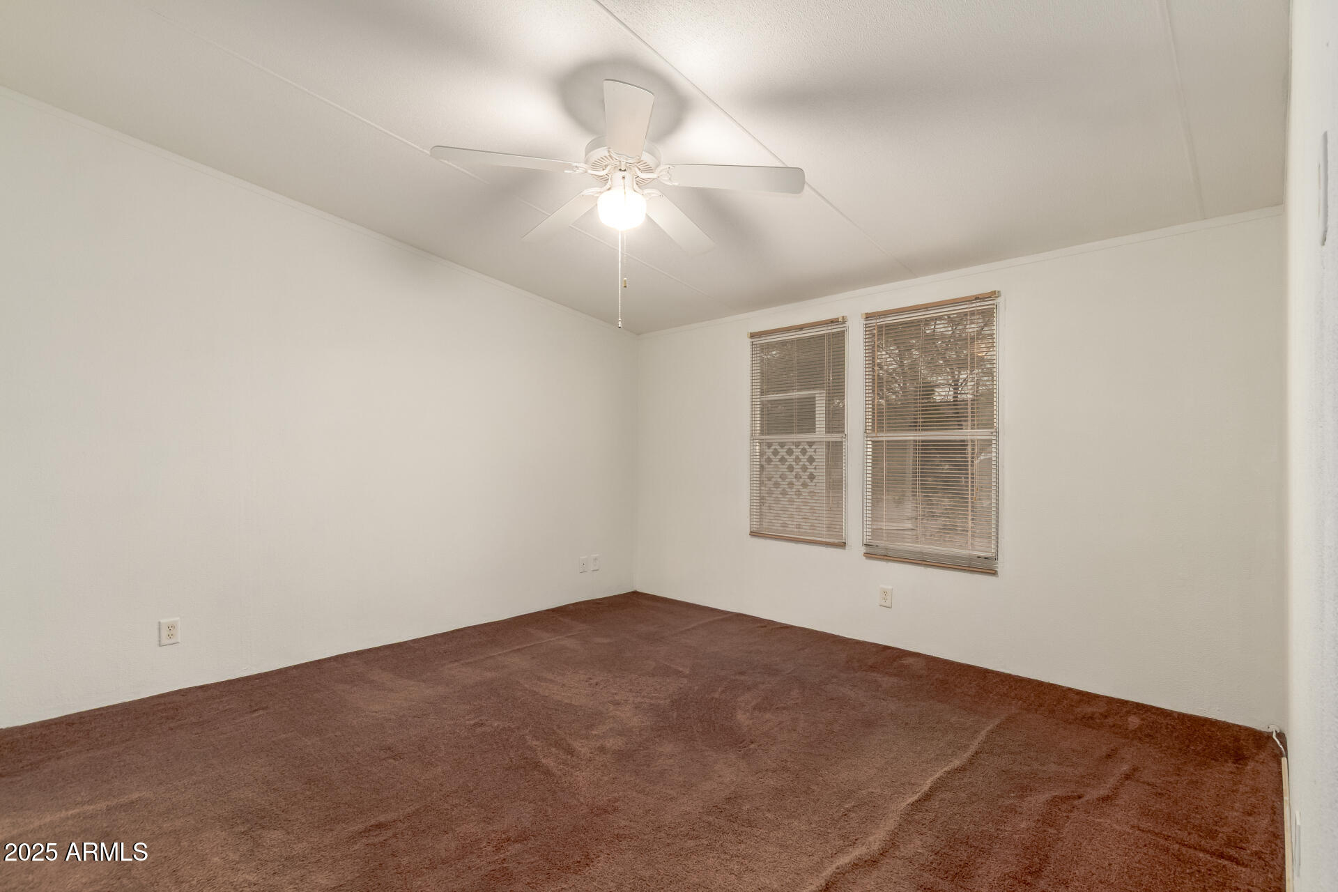 11404 West Custer Road Arizona City, AZ 85123 - Photo 9 of 27 an empty room with a chandelier fan and windows