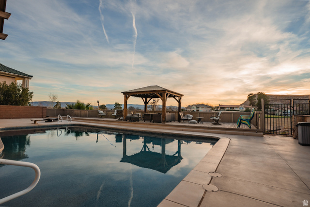 980 Cactus Circle St. George, UT 84790 - Photo 40 of 77 Pool at dusk featuring a gazebo, a patio area, and a fenced backyard