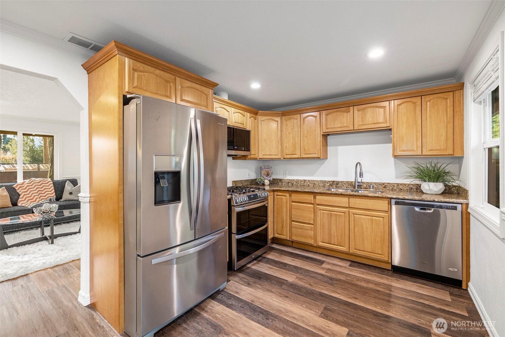 19006 Southeast 269th Street Covington, WA 98042 - Photo 8 of 32 a kitchen with granite countertop stainless steel appliances a sink cabinets and a window