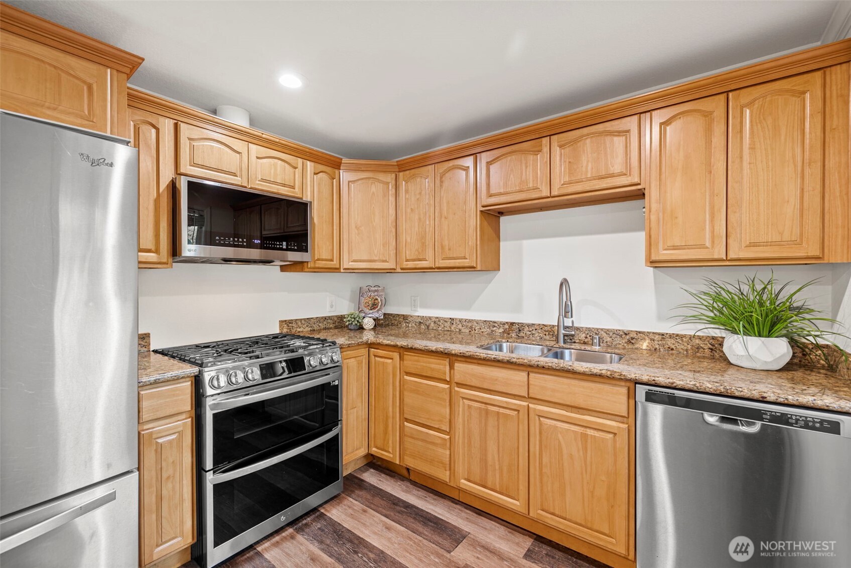 19006 Southeast 269th Street Covington, WA 98042 - Photo 9 of 32 a kitchen with stainless steel appliances granite countertop a stove a sink and a microwave