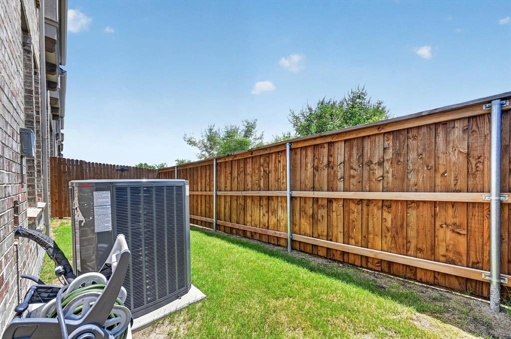 1153 Queensdown Way Forney, TX 75126 - Photo 26 of 26 Fenced yard area featuring a brick exterior, a manicured lawn, and a wooden privacy fence with metal posts