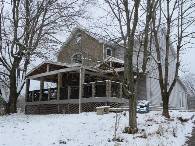 a view of wooden house with snow on the background