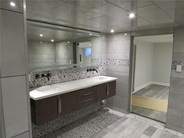 a bathroom with a granite countertop sink a mirror and shower
