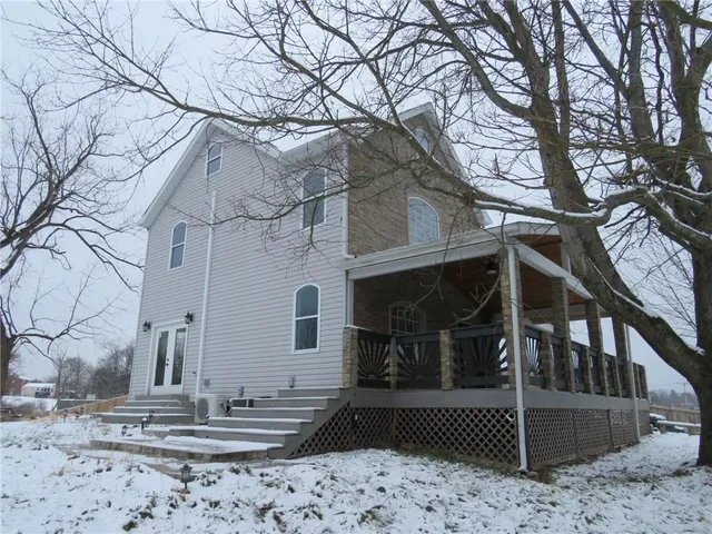 a view of a white house with a large tree