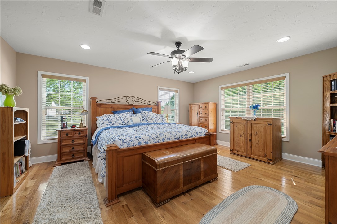 304 West A 144 Walhalla, SC 29691 - Photo 29 of 43 This spacious sleeping quarter features luminous hardwood floors and multiple windows, creating a bright and airy atmosphere.