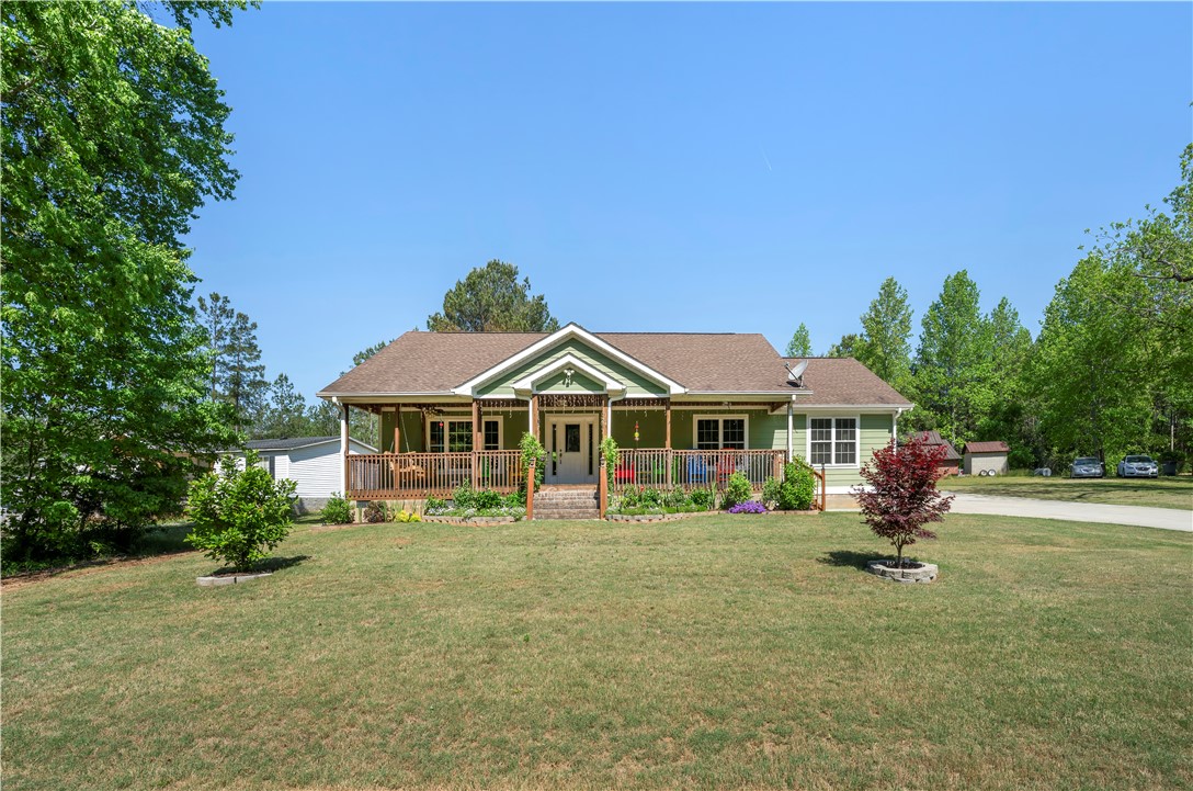 304 West A 144 Walhalla, SC 29691 - Photo 39 of 43 This inviting home features a charming front porch, set against a backdrop of lush green trees and a clear sky.