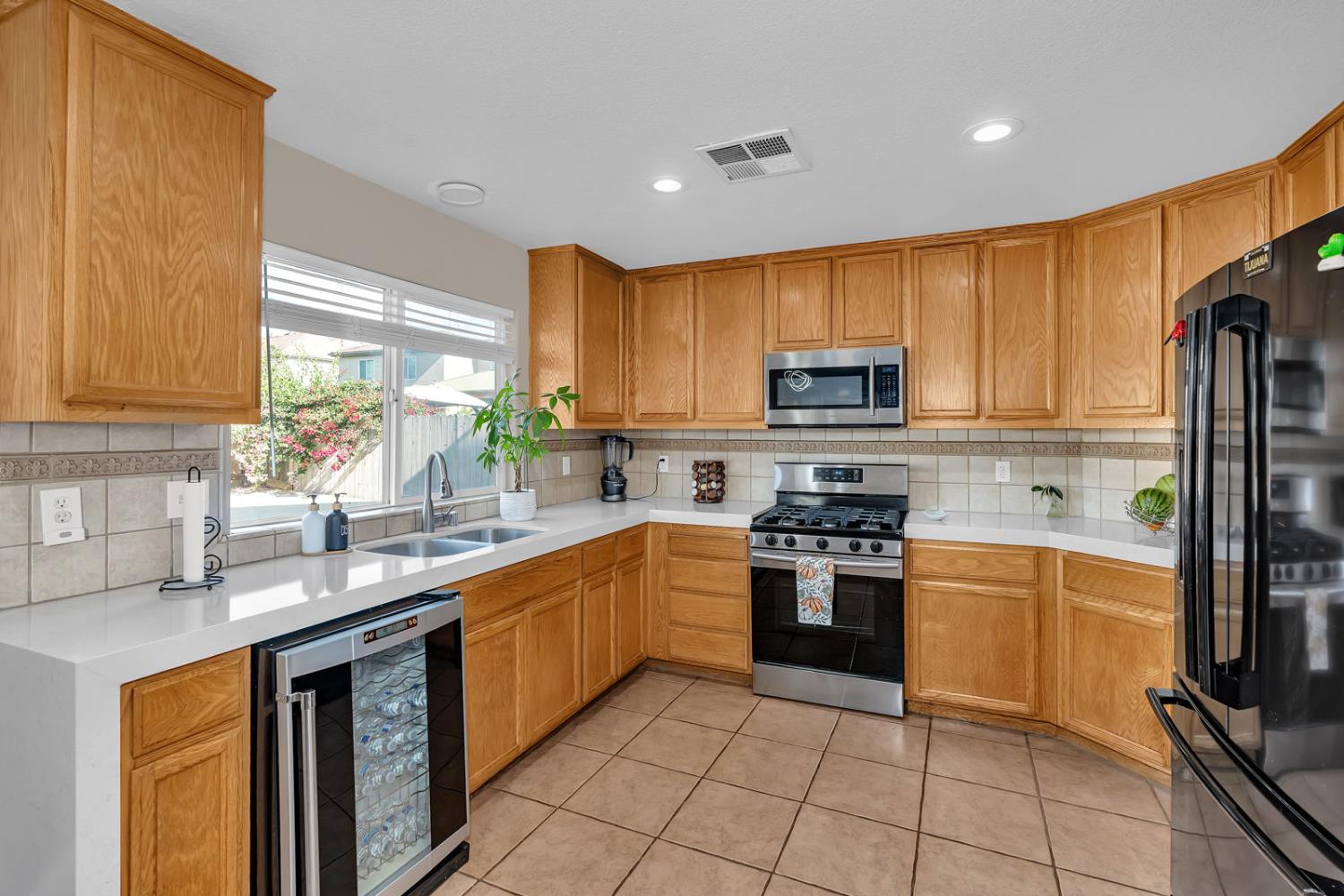 1406 San Rafael Street Los Banos, CA 93635 - Photo 12 of 35 a kitchen with stainless steel appliances granite countertop a stove top oven a sink dishwasher and a refrigerator