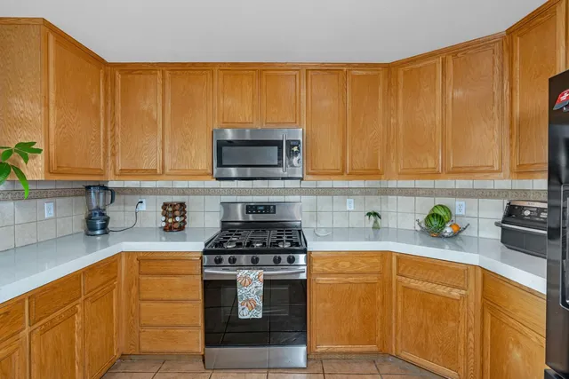 a kitchen with stainless steel appliances a stove a sink a microwave and cabinets