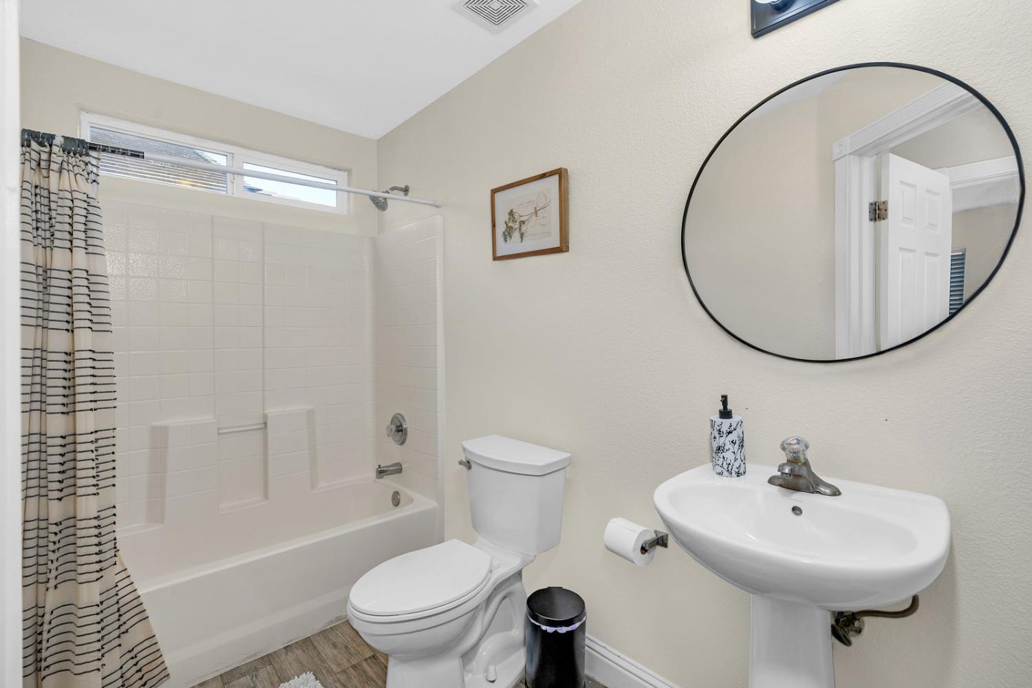 1406 San Rafael Street Los Banos, CA 93635 - Photo 17 of 35 a bathroom with a sink a toilet and a mirror