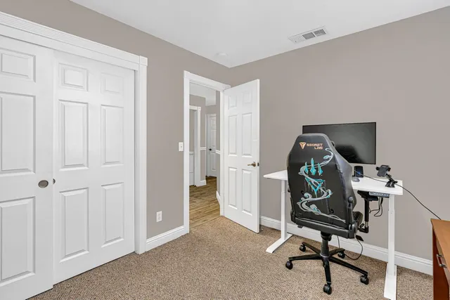 a view of a workspace with furniture and a window