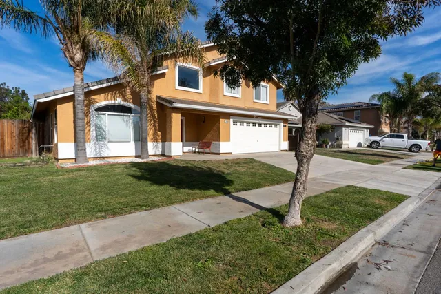 a front view of a house with a yard and palm tree