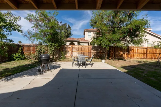 a view of a patio with table and chairs and potted plants