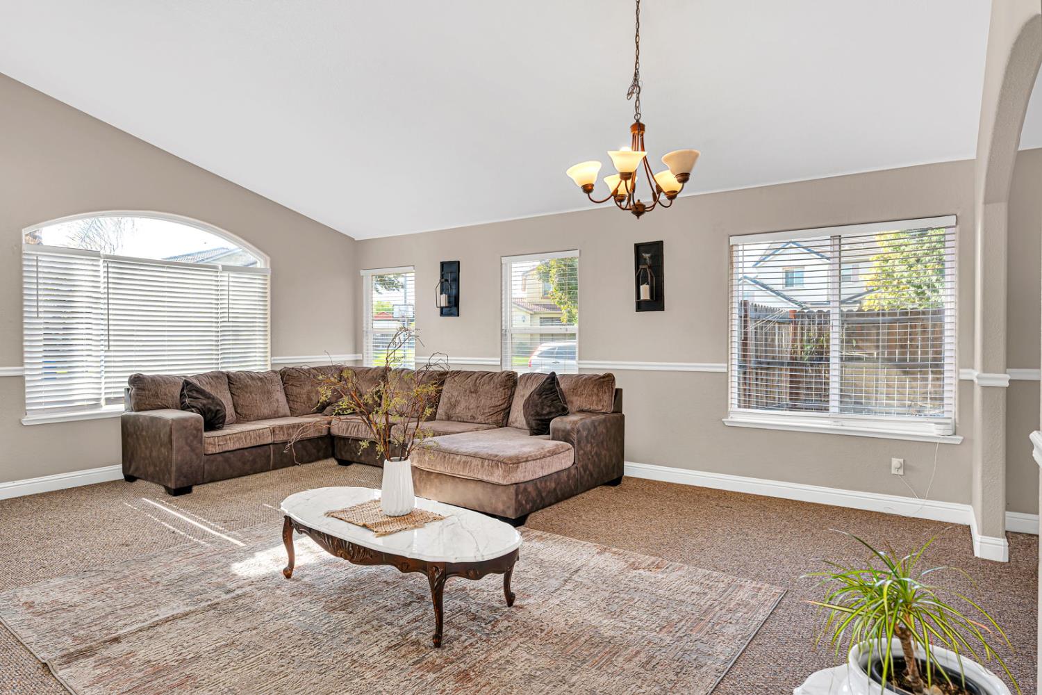 1406 San Rafael Street Los Banos, CA 93635 - Photo 4 of 35 a living room with couch a dining table and a chandelier