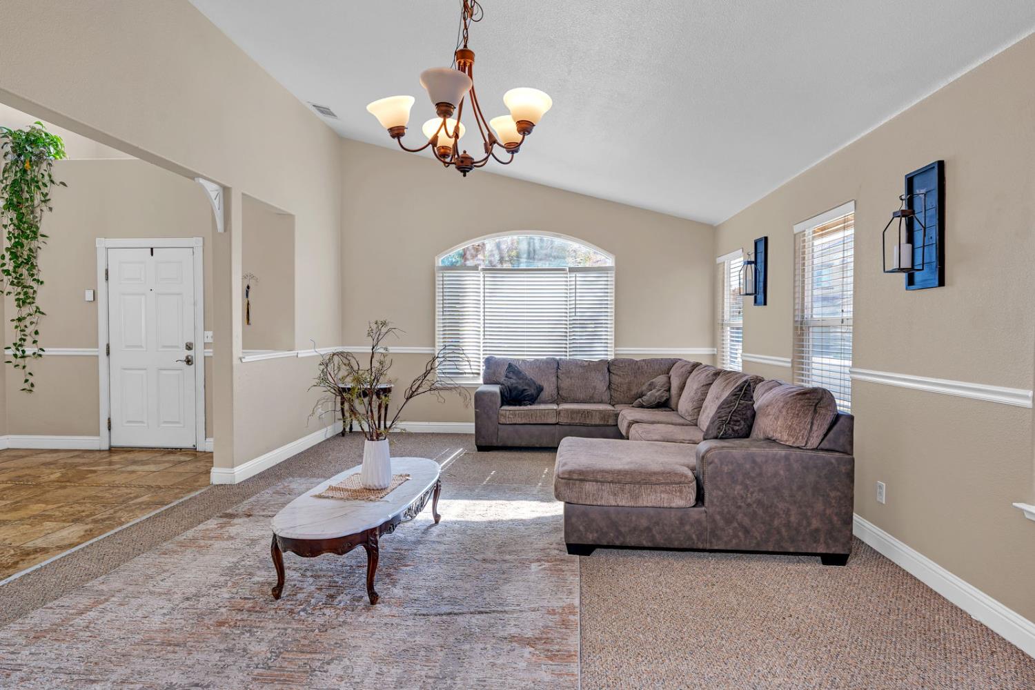 1406 San Rafael Street Los Banos, CA 93635 - Photo 6 of 35 a living room with furniture a chandelier and a dining room