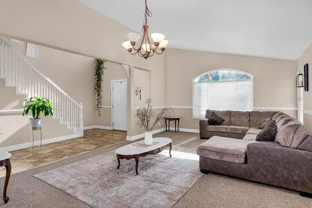 a living room with furniture a window and a chandelier
