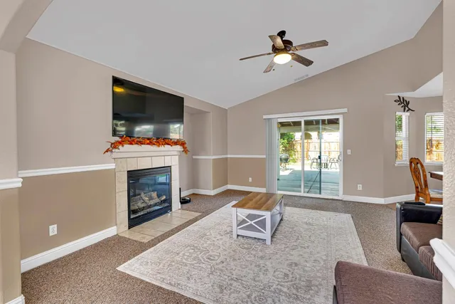 a living room with furniture a flat screen tv and a fireplace