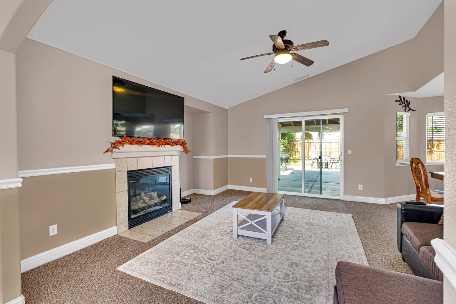 1406 San Rafael Street Los Banos, CA 93635 - Photo 8 of 35 a living room with furniture a flat screen tv and a fireplace