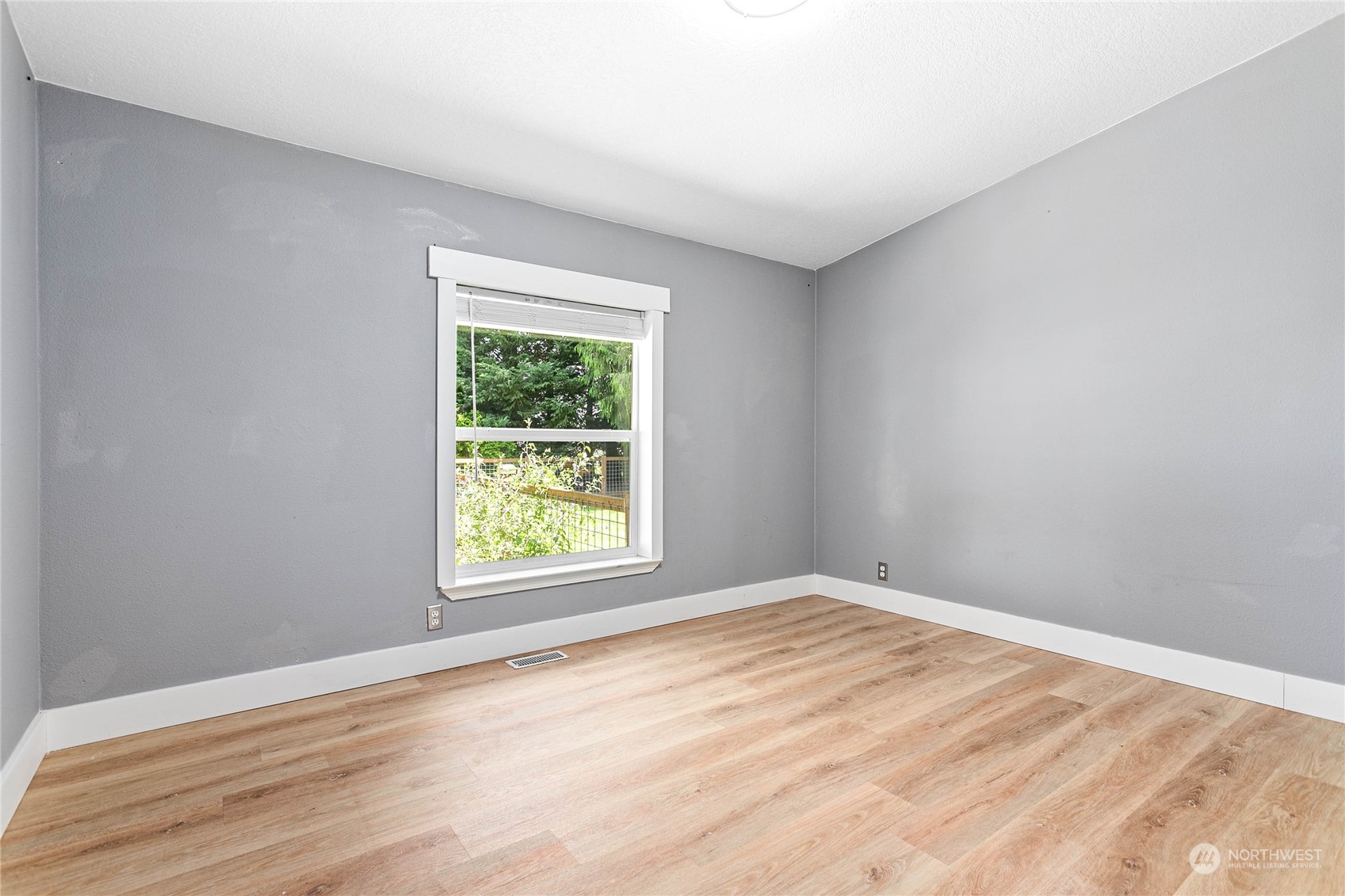 8338 Bob Hall Road Lynden, WA 98264 - Photo 17 of 37 a view of an empty room with wooden floor and a window