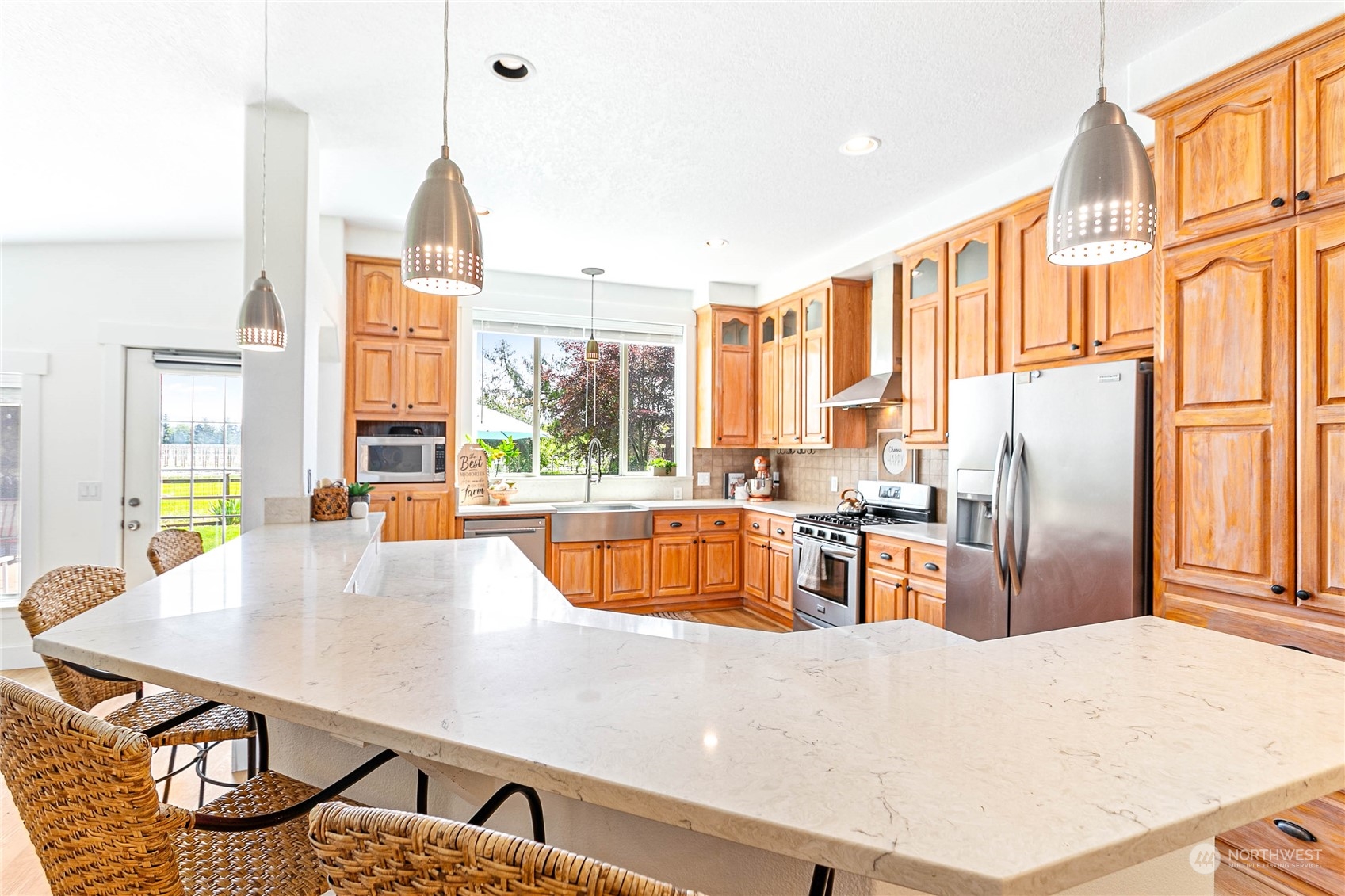 8338 Bob Hall Road Lynden, WA 98264 - Photo 8 of 37 a kitchen with stainless steel appliances kitchen island granite countertop a refrigerator a stove and white cabinets with wooden floors