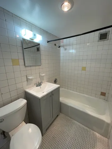 a bathroom with a sink mirror vanity and toilet