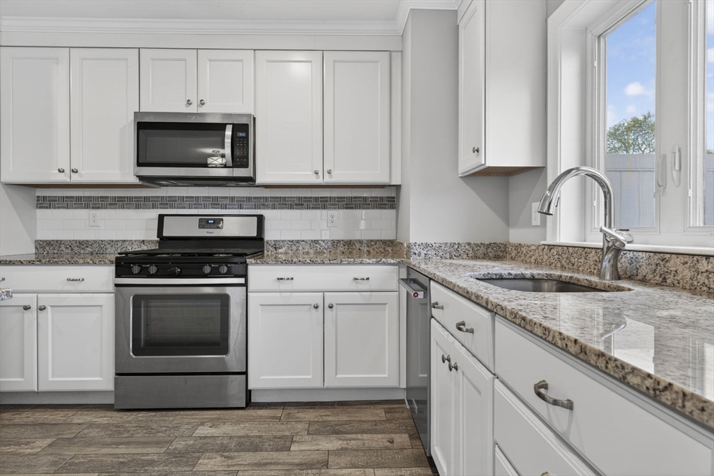 129 Acton Street, Unit 16 Maynard, MA 01754 - Photo 11 of 41 a kitchen with granite countertop white cabinets and appliances