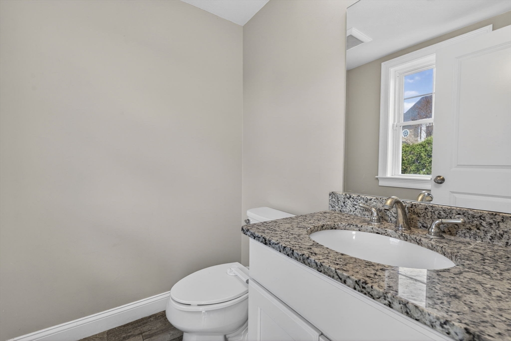 129 Acton Street, Unit 16 Maynard, MA 01754 - Photo 13 of 41 a bathroom with a granite countertop sink a toilet and a mirror