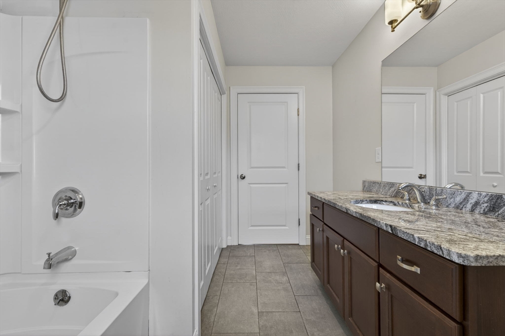129 Acton Street, Unit 16 Maynard, MA 01754 - Photo 18 of 41 a bathroom with a granite countertop sink and a mirror