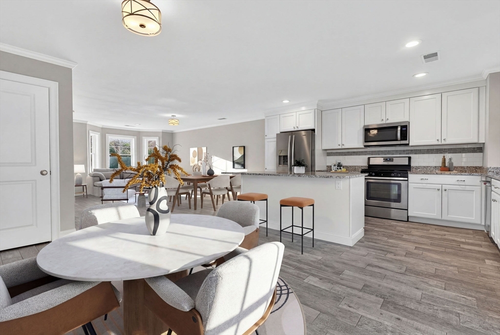 129 Acton Street, Unit 16 Maynard, MA 01754 - Photo 2 of 41 a kitchen with microwave a refrigerator and chairs