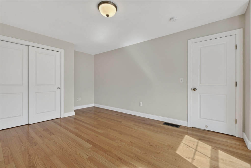 129 Acton Street, Unit 16 Maynard, MA 01754 - Photo 22 of 41 a view of an empty room with wooden floor