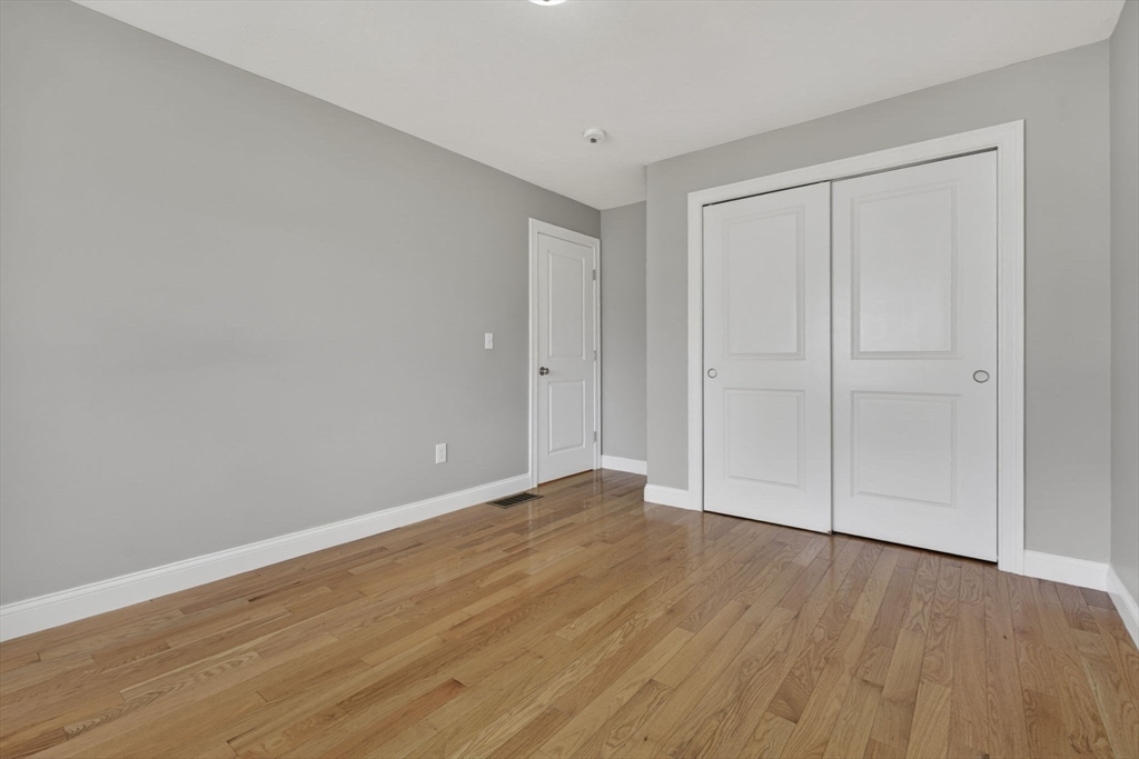129 Acton Street, Unit 16 Maynard, MA 01754 - Photo 25 of 41 a view of an empty room with wooden floor
